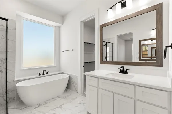 a bathroom with a double vanity sink mirror and bathtub