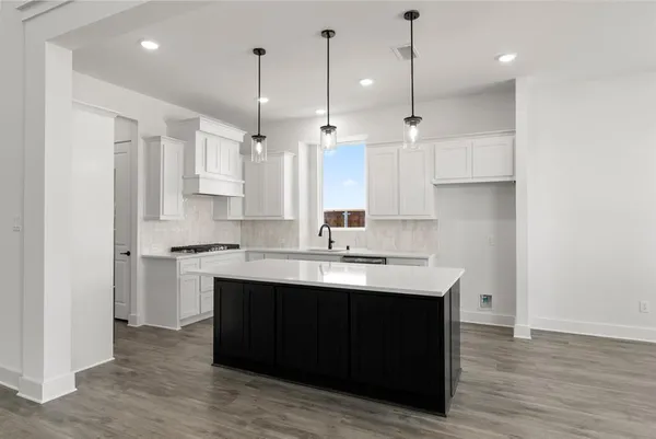 a kitchen with kitchen island a sink stainless steel appliances and cabinets