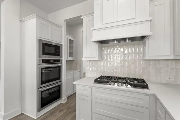 a kitchen with granite countertop a stove and a microwave