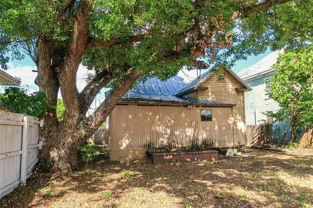 a front view of a house with a tree