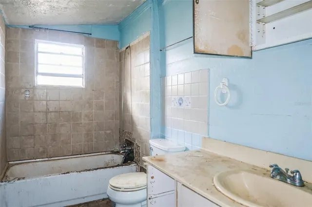 a bathroom with a granite countertop sink toilet a mirror and shower