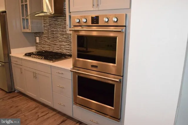 a stove top oven sitting inside of a kitchen