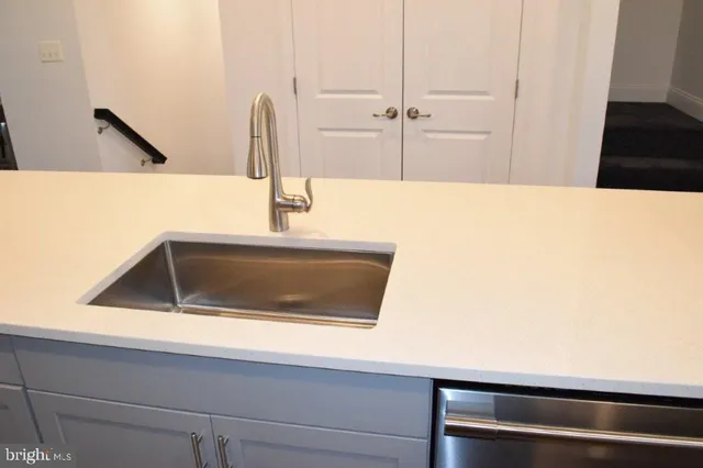 a kitchen with stainless steel appliances kitchen island granite countertop a refrigerator and a sink