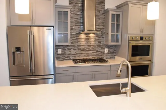 a kitchen with stainless steel appliances a refrigerator and a sink