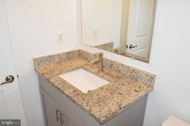 a bathroom with a granite countertop toilet and a bathtub
