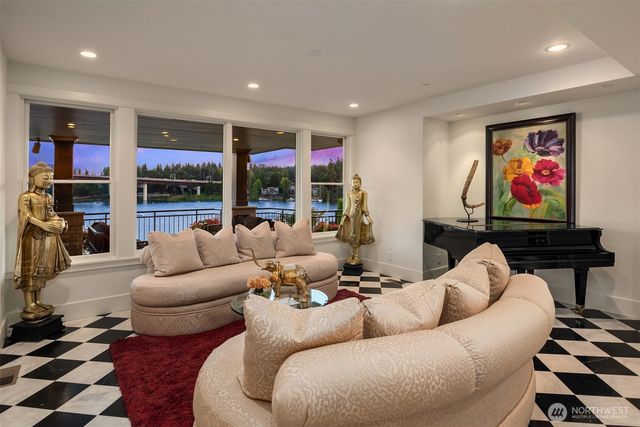 a living room with furniture a flat screen tv and a floor to ceiling window