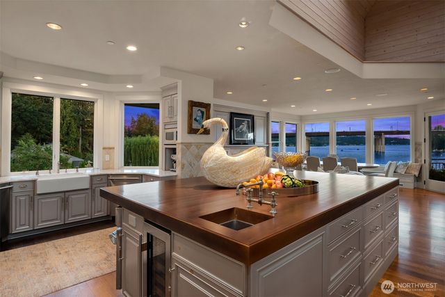 a view of kitchen island a sink and a large window