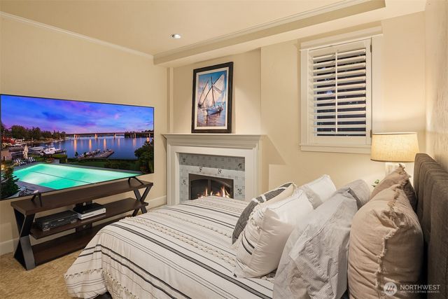 a bed sitting in a bedroom next to a window with a flat screen tv