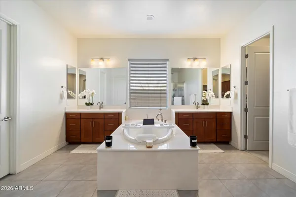 a bathroom with a tub sink and mirror