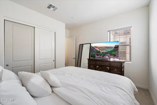 a bedroom with a bed and a flat screen tv
