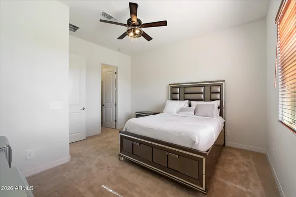 a bed sitting in a bedroom next to a window