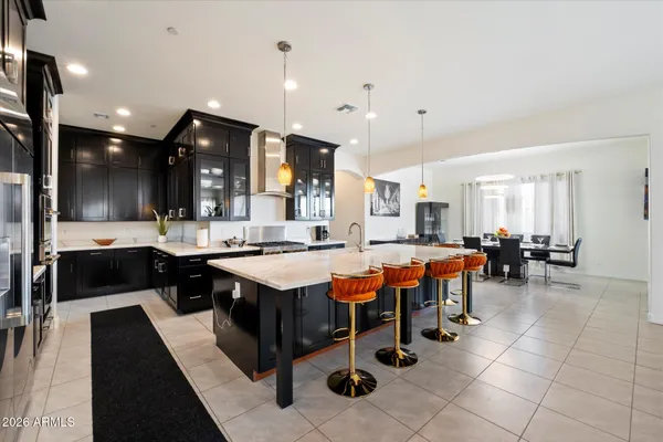 a large dining hall with stainless steel appliances granite countertop a table and chairs