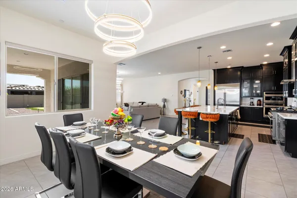 a dining room with stainless steel appliances kitchen island granite countertop a dining table and chairs