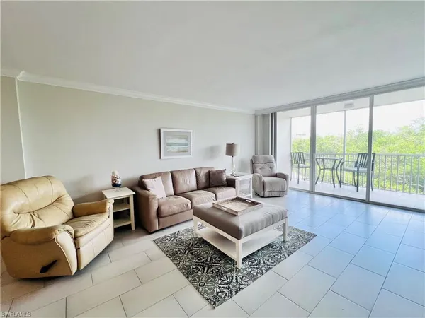 a living room with furniture and a floor to ceiling window
