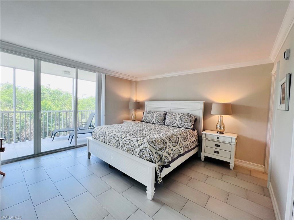 5 Bluebill Avenue, Unit 3031 Naples, FL 34108 - Photo 14 of 24 a bedroom with a bed and a large window
