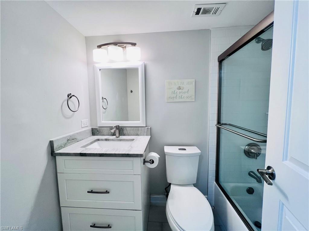 5 Bluebill Avenue, Unit 3031 Naples, FL 34108 - Photo 19 of 24 a bathroom with a granite countertop toilet sink and mirror