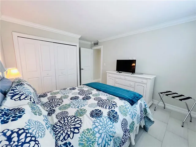 a bedroom with a bed and a tv