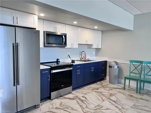 a kitchen with stainless steel appliances granite countertop a refrigerator stove a sink and a microwave