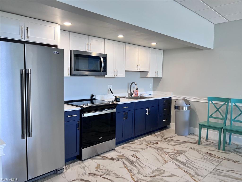 5 Bluebill Avenue, Unit 3031 Naples, FL 34108 - Photo 7 of 24 a kitchen with stainless steel appliances granite countertop a refrigerator stove a sink and a microwave