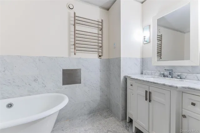 a bathroom with a tub sink and mirror