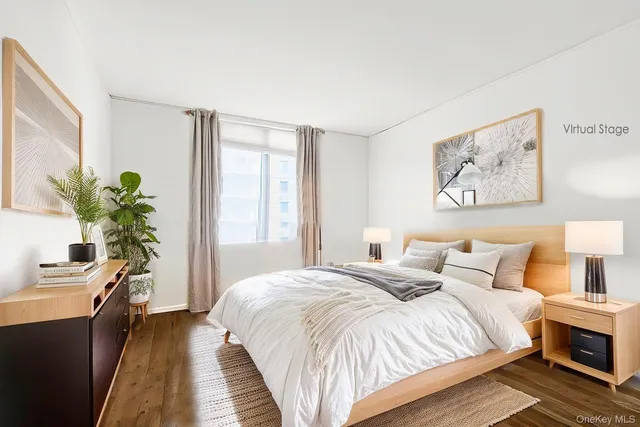 a bedroom with a large bed and a potted plant