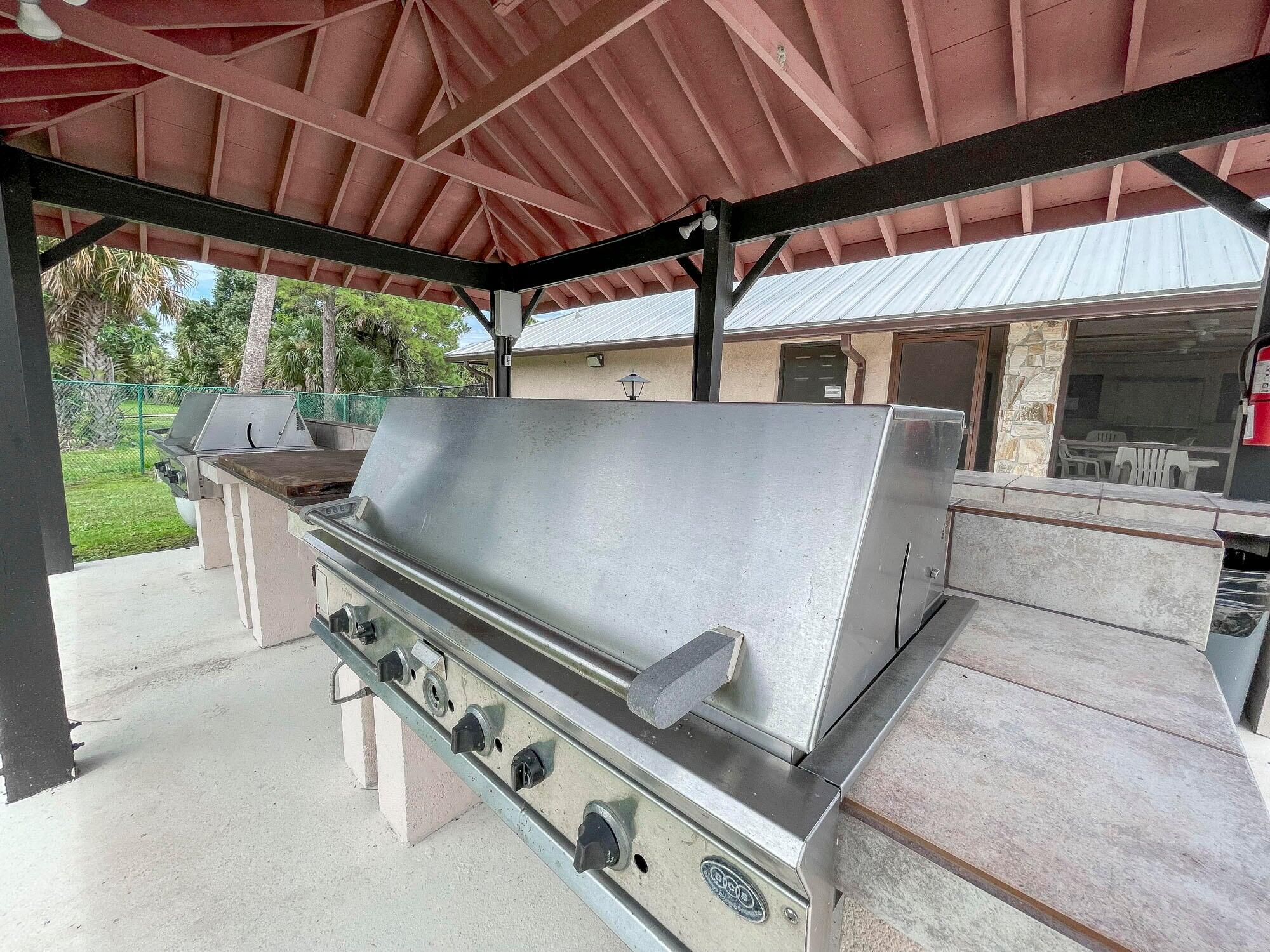 2779 Southwest Olds Place Stuart, FL 34997 - Photo 40 of 41 a roof deck with table and chairs under an umbrella