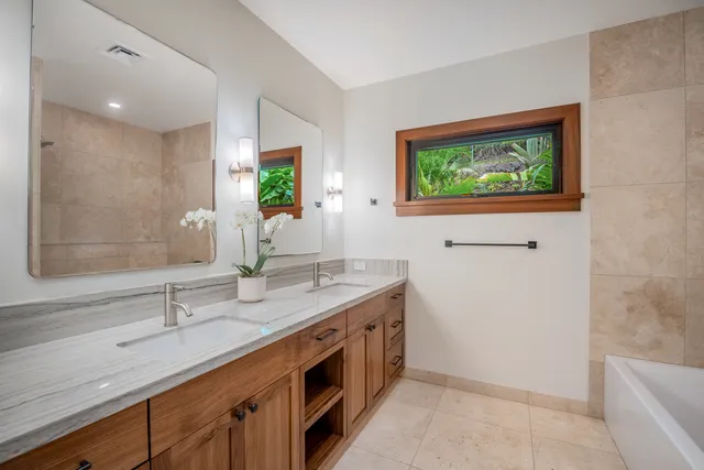 an empty room with wooden floor chandelier and windows