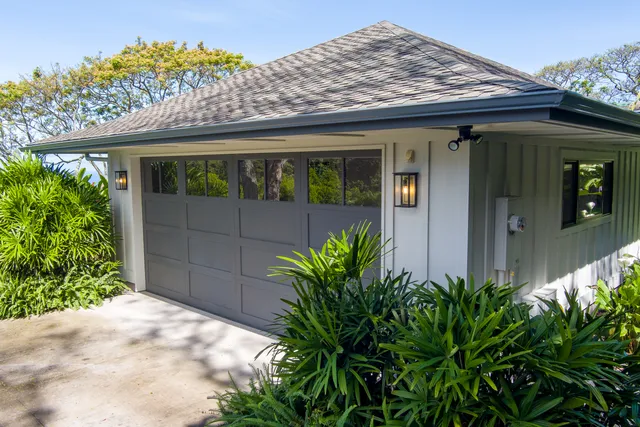 an aerial view of residential houses with outdoor space and trees