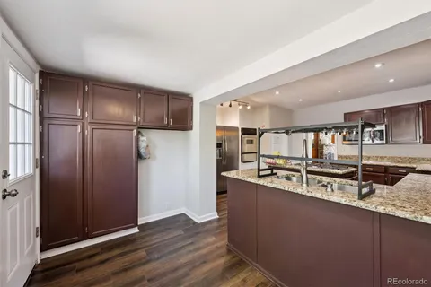 a large kitchen with stainless steel appliances granite countertop a refrigerator and a sink