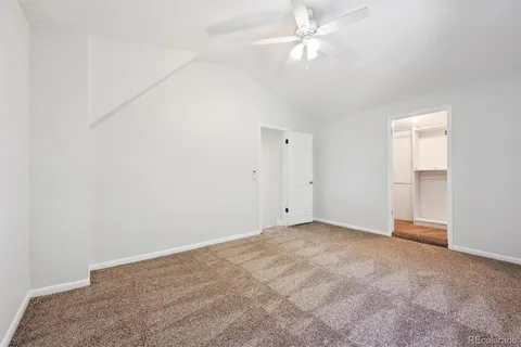 an empty room with a ceiling fan and a fan
