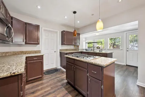 a kitchen with a stove and a wooden floor