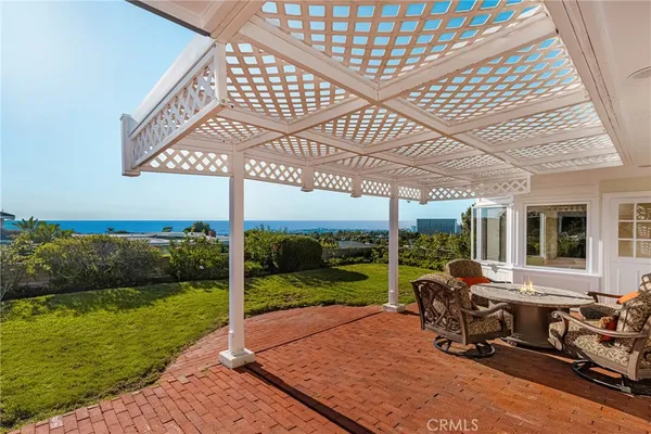 a view of a patio with table and chairs potted plants and floor to ceiling window