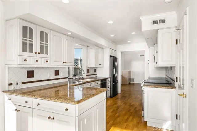 a kitchen with stainless steel appliances granite countertop a sink stove and refrigerator