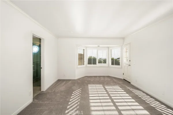 a view of a bedroom with wooden floor and windows