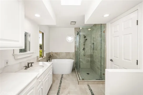 a bathroom with a bathtub shower sink mirror and toilet