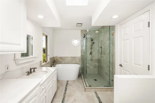 a bathroom with a bathtub shower sink mirror and toilet