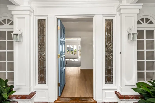 a view of a hallway with wooden floor and a living room