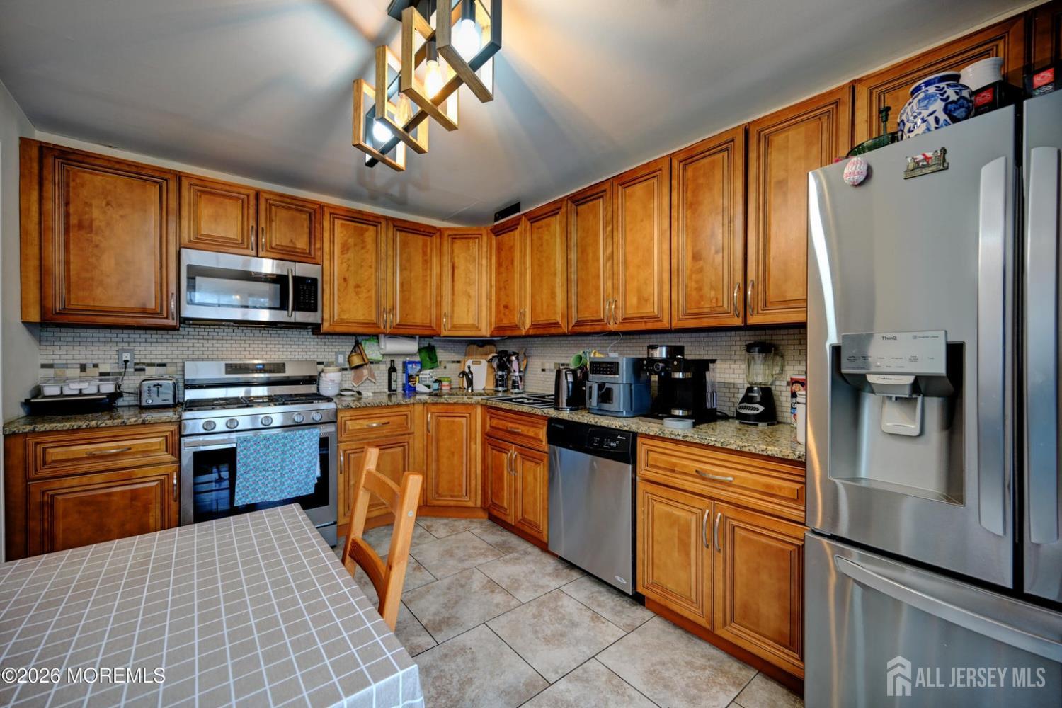 22 Borell Square Parlin, NJ 08859 - Photo 11 of 32 a kitchen with stainless steel appliances granite countertop wooden cabinets a stove top oven a sink and dishwasher