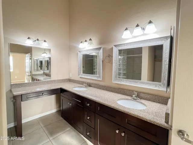 a spacious bathroom with a granite countertop sink and a large mirror
