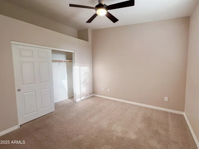 an empty room with fan and windows