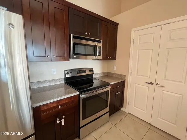 a kitchen with wooden cabinets and stainless steel appliances