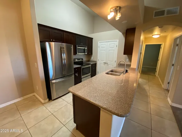 a kitchen with stainless steel appliances a refrigerator a sink a stove a microwave and island