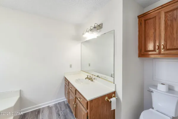 an empty room with wooden floor cabinet and windows