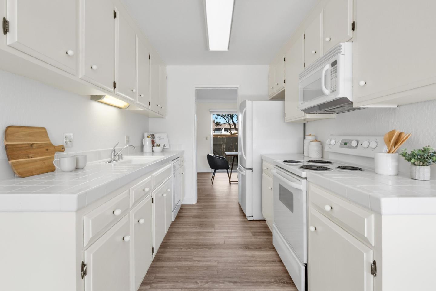 120 Paseo Ballena Aptos, CA 95003 - Photo 13 of 69 a large white kitchen with stainless steel appliances granite countertop lots of counter space and wooden floor