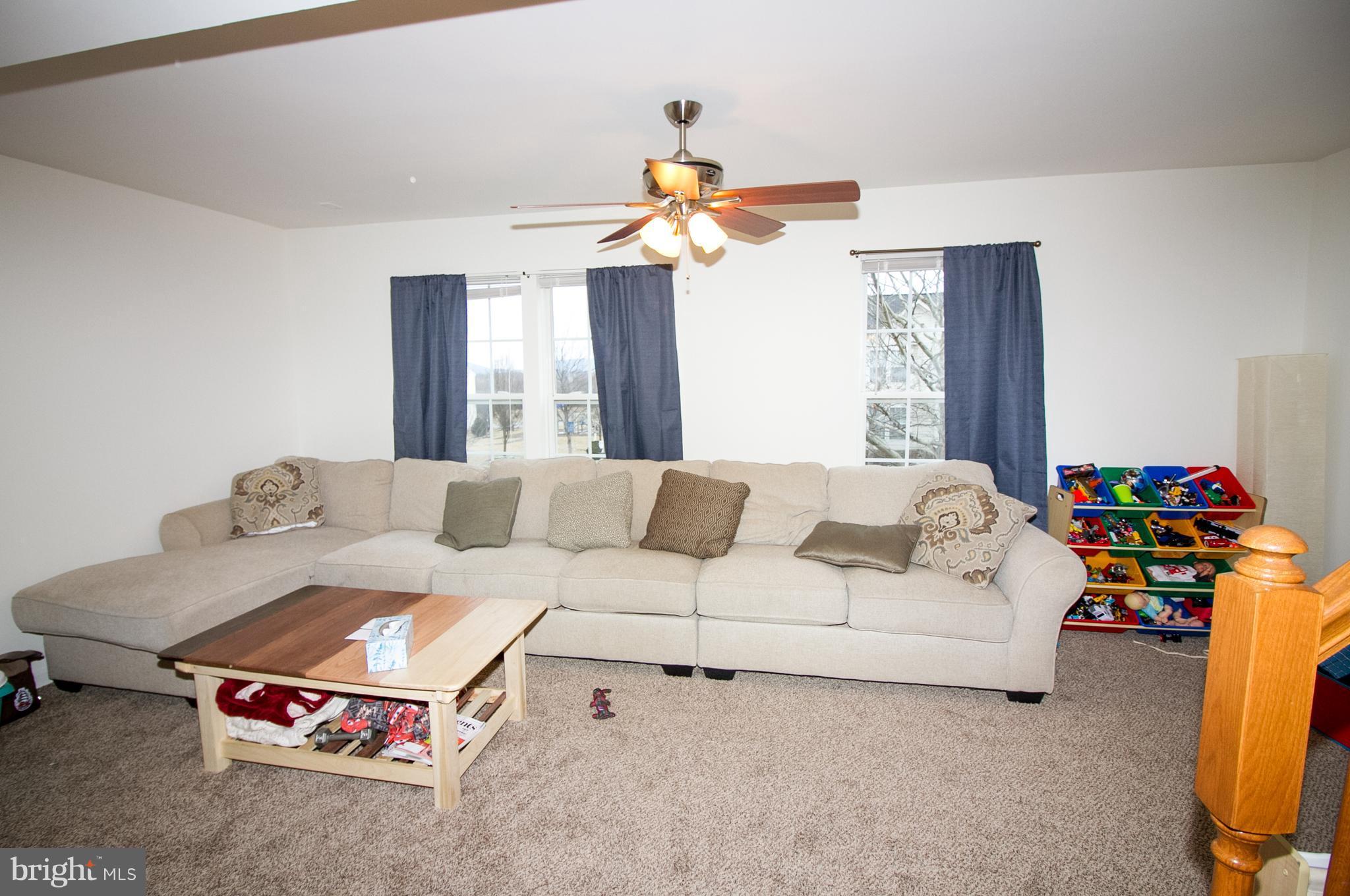 1253 Steed Street Ranson, WV 25438 - Photo 13 of 18 a living room with furniture and a chandelier