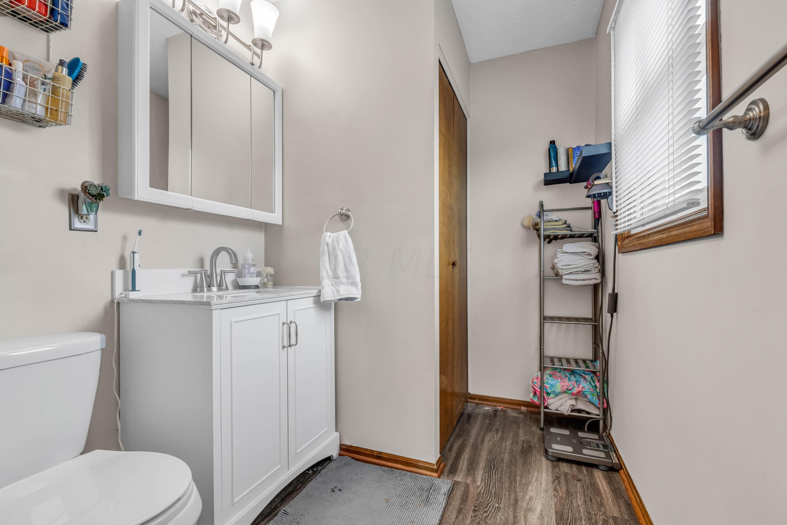 435 Emory Street Gahanna, OH 43230 - Photo 27 of 54 • New luxury vinyl plank flooring
• Tan painted walls
• Shower stall with glass doors
• Enclosed vanity with single
bowl, cultured marble sinktop
• Ceiling exhaust
• Mirrored medicine cabinet
• 3 bulb wall light
• Linen closet with bifold doors
• Mini blinds