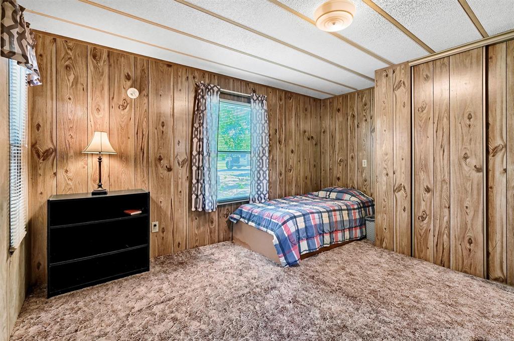 36 Atlantic Street Pottsboro, TX 75076 - Photo 12 of 21 Bedroom with carpet flooring, wooden walls, and a closet
