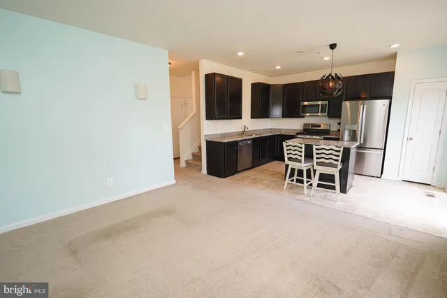 a kitchen with stainless steel appliances a stove a sink a microwave a refrigerator and cabinets