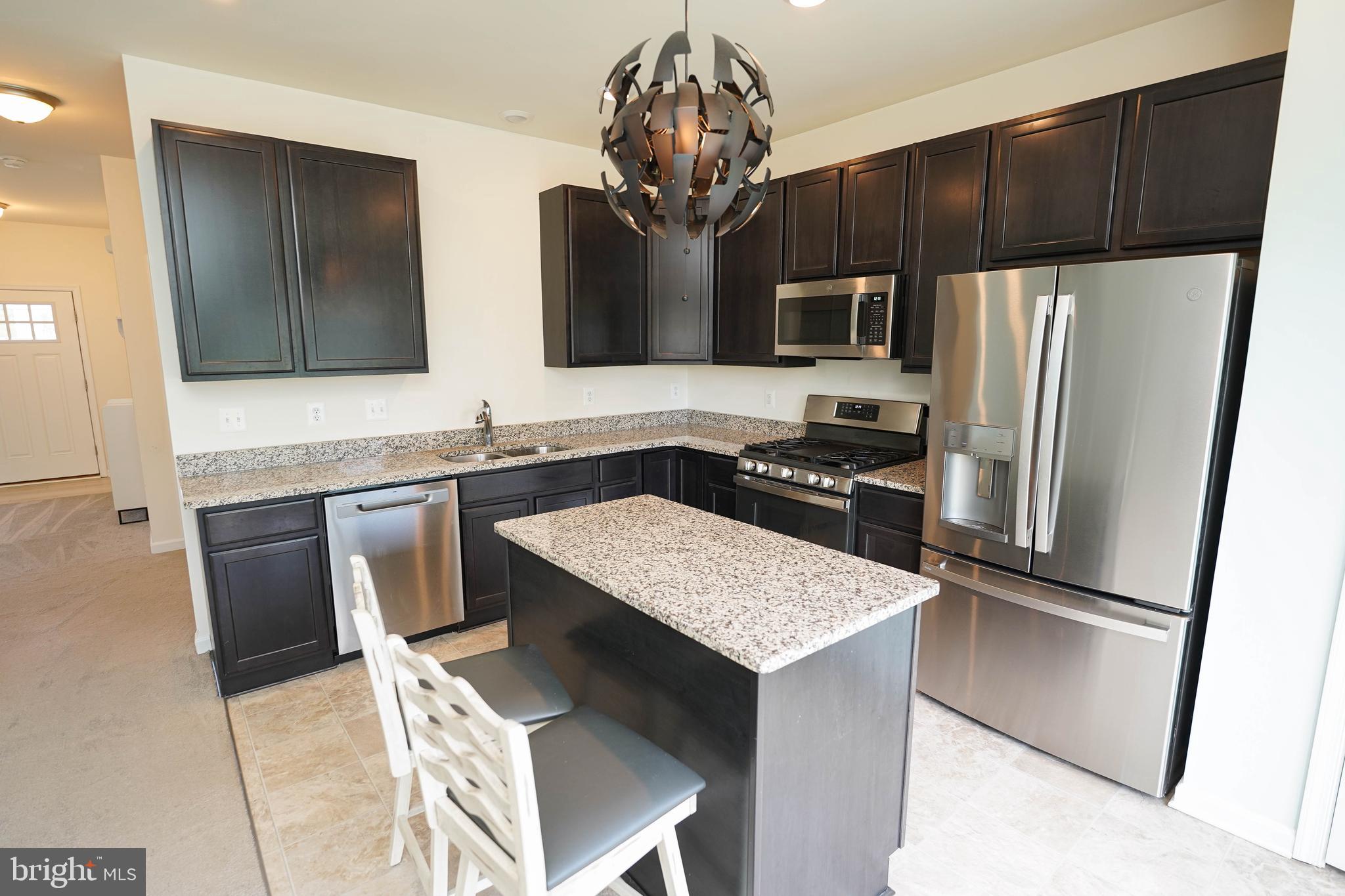 322 Appleby School Road Cambridge, MD 21613 - Photo 27 of 58 a kitchen with kitchen island granite countertop a sink refrigerator and microwave