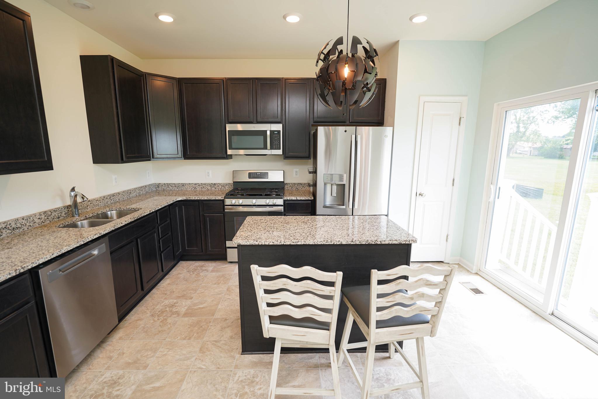 322 Appleby School Road Cambridge, MD 21613 - Photo 31 of 58 a kitchen with stainless steel appliances a stove a sink a microwave a refrigerator and cabinets